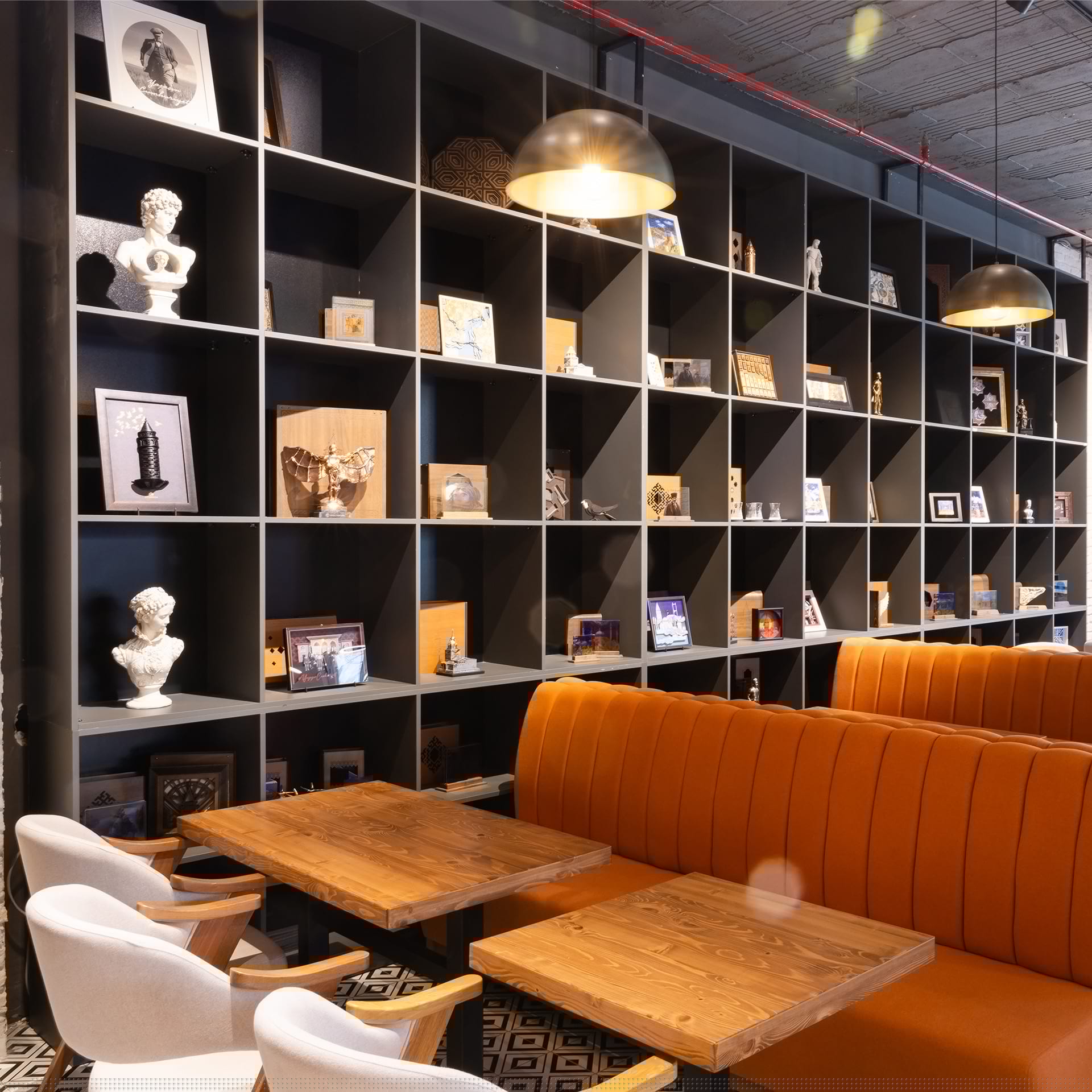 Lounge alanı; turuncu koltuk ve kitaplık